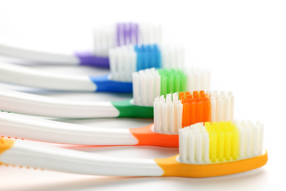 Close up of multicolored toothbrushes on white background